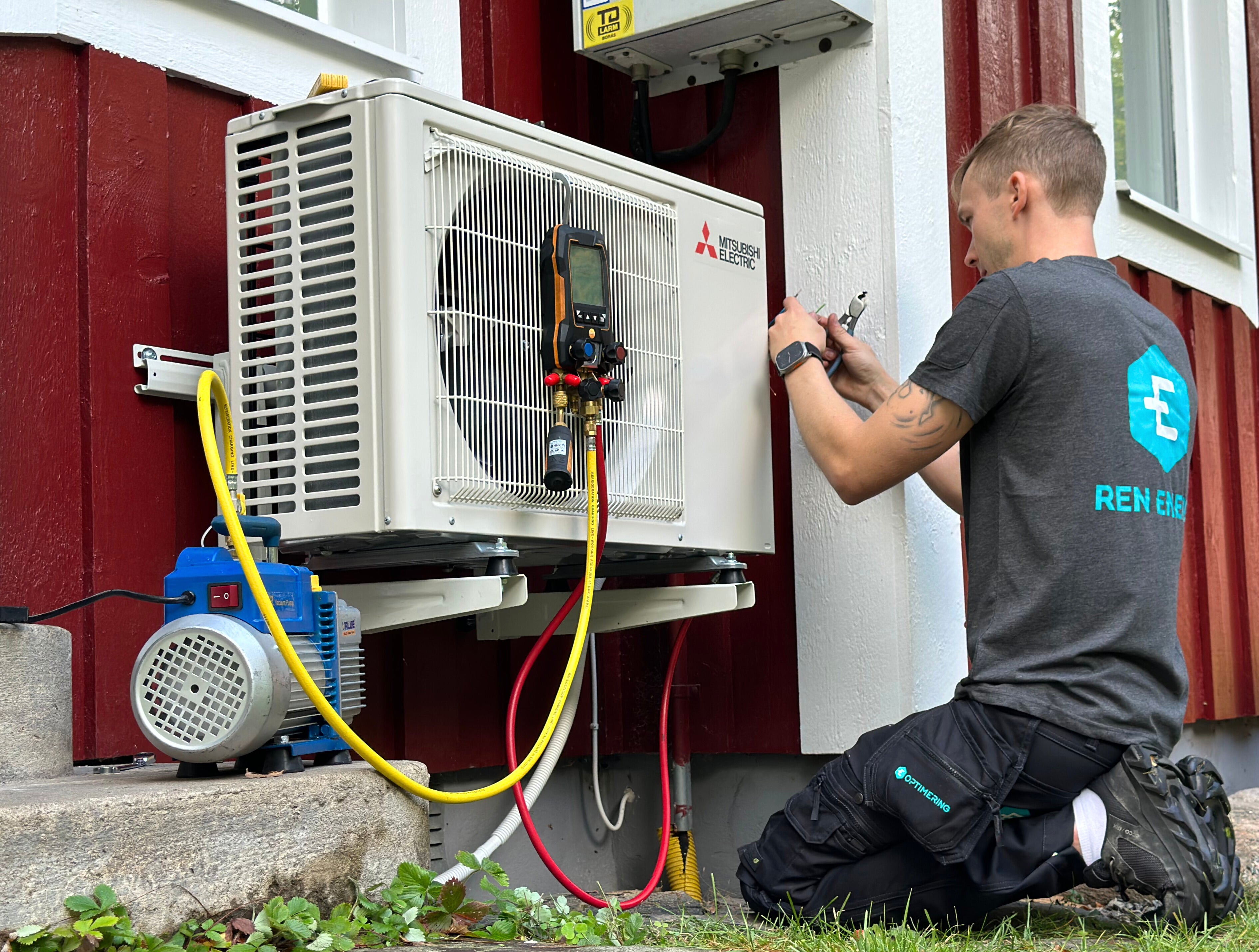 Certifierad kyltekniker installerar en värmepump från Eoptimering.